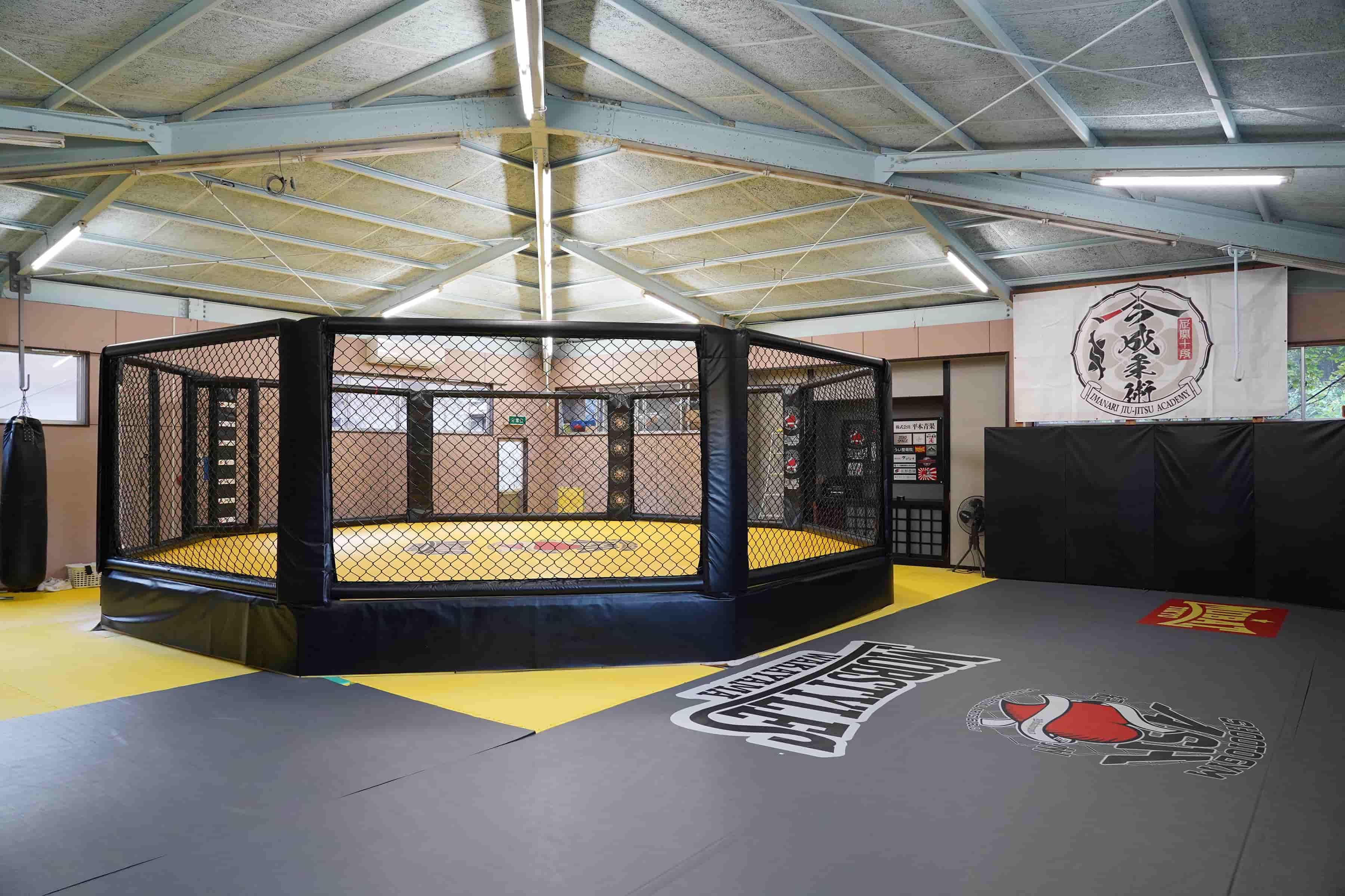 ジム内の八角形の本格金網リング(オクタゴン)とトレーニングスペース
